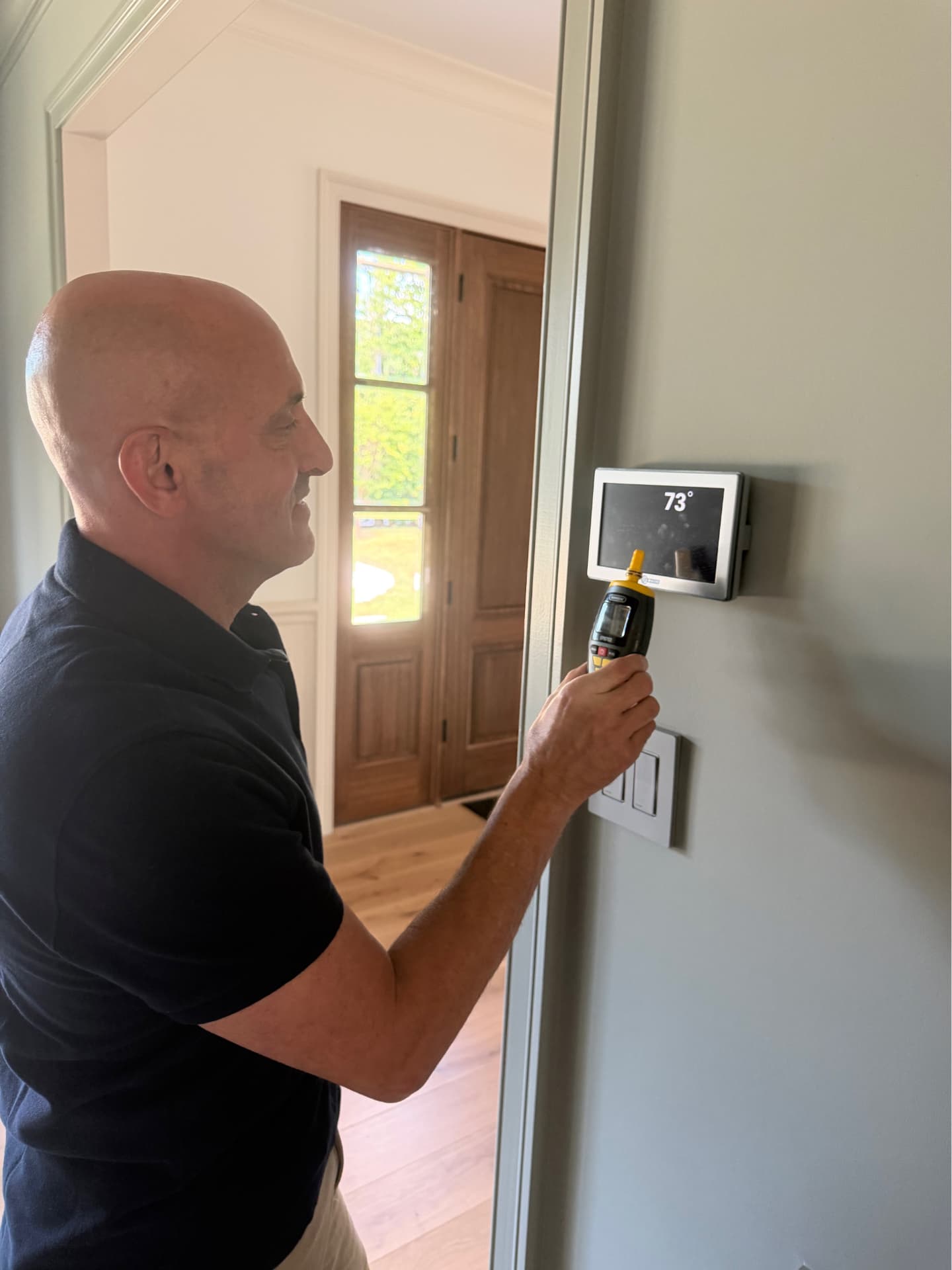 Robert checking a home's thermostat